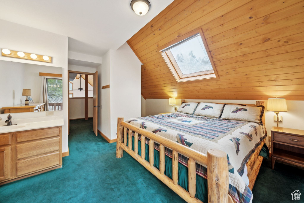 Bedroom featuring a skylight, carpet, and a sink