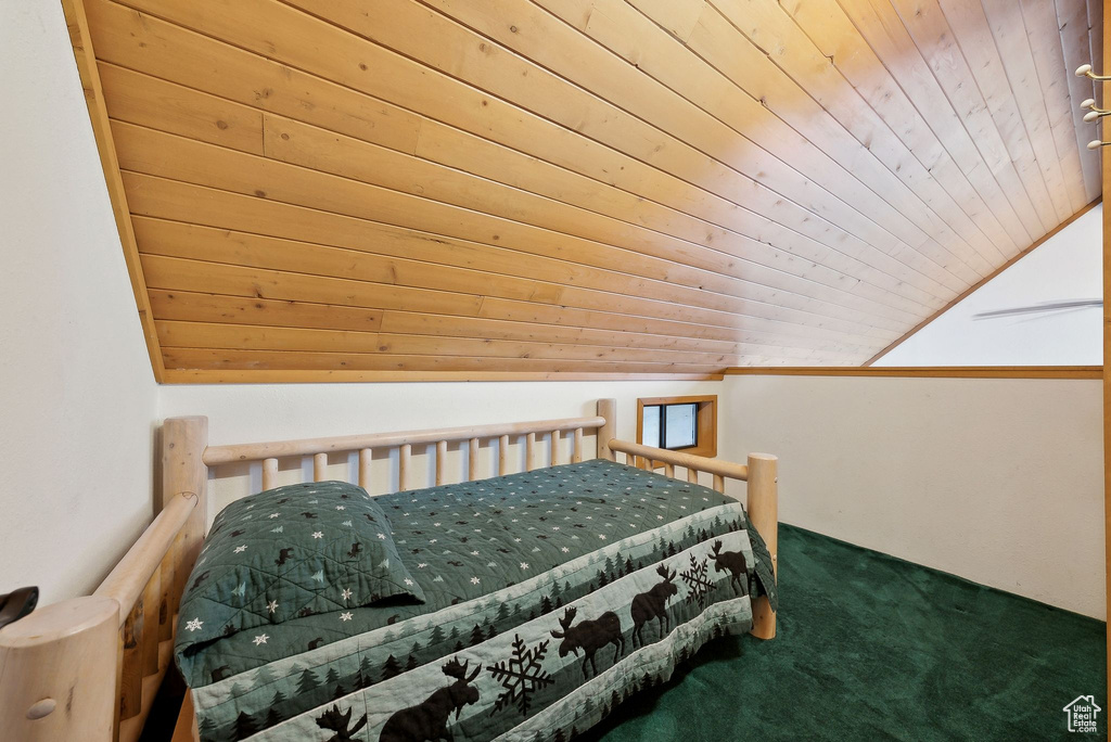 Carpeted bedroom featuring wood ceiling and lofted ceiling