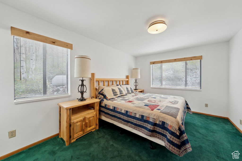 Bedroom with dark carpet and baseboards
