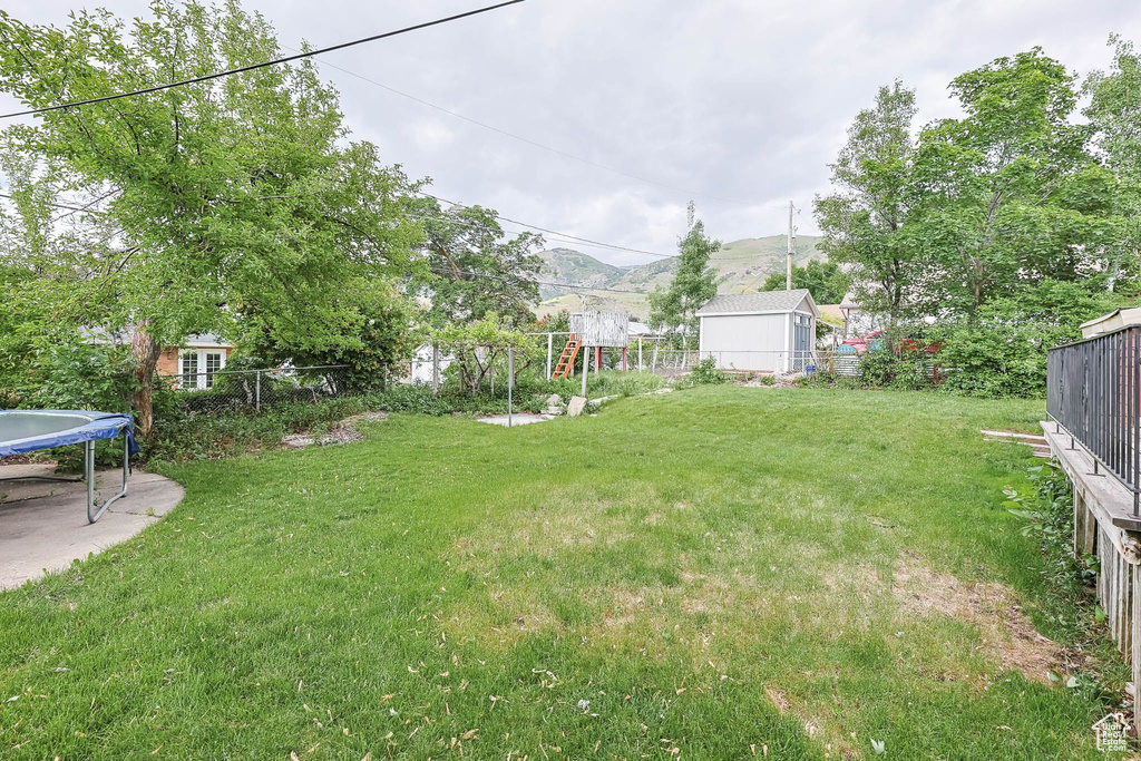 View of yard featuring a trampoline and a mountain view