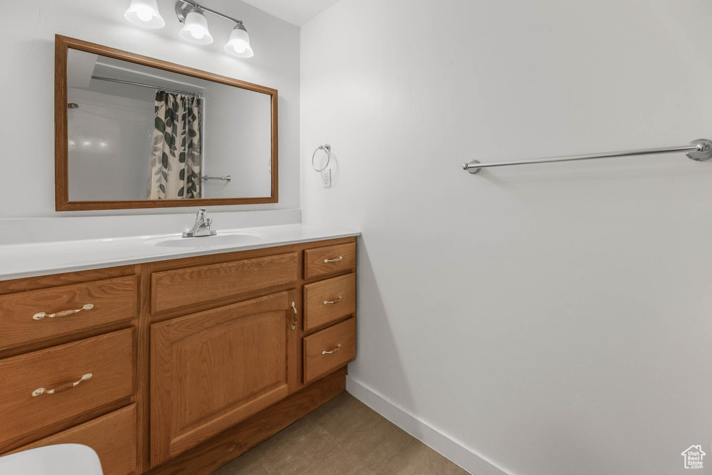 Bathroom with vanity, baseboards, toilet, and a shower with shower curtain