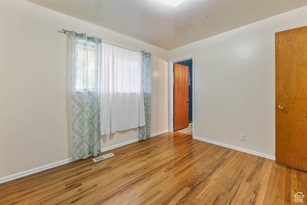 Unfurnished room with wood finished floors and baseboards