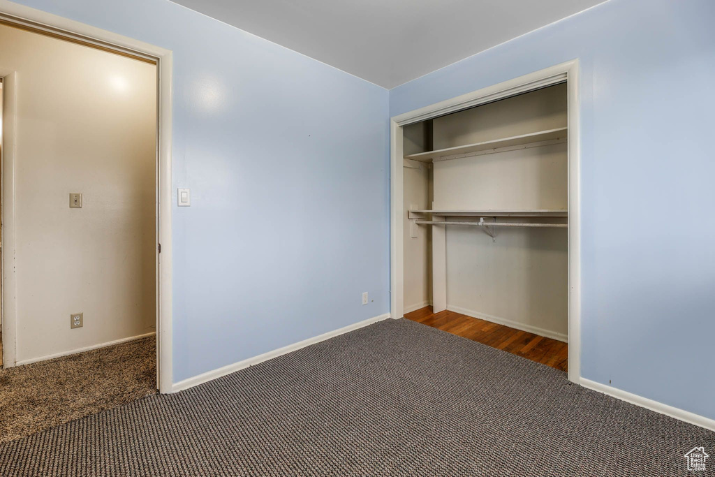 Unfurnished bedroom with carpet, a closet, and baseboards
