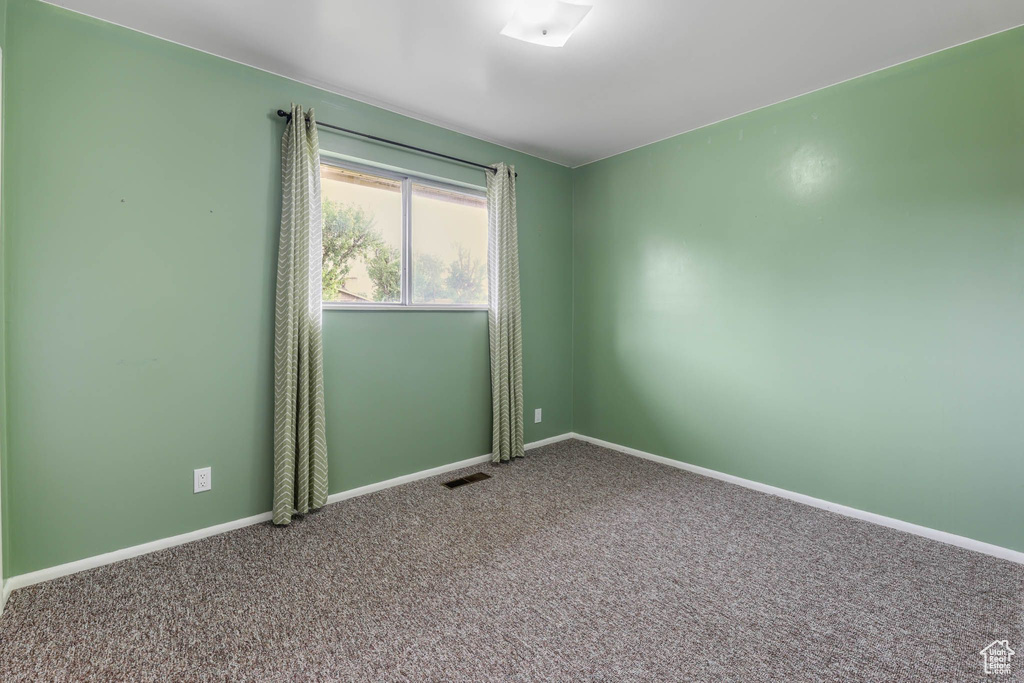 Carpeted spare room with baseboards