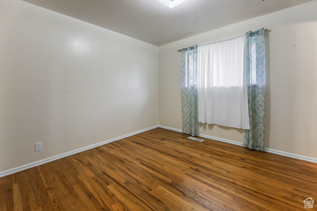Unfurnished room with baseboards and wood finished floors