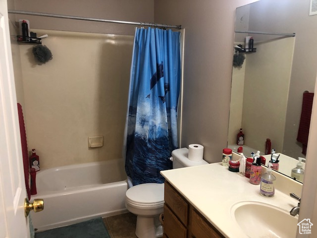 Full bathroom with toilet, shower / bath combo, tile patterned flooring, and vanity