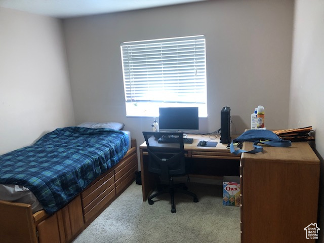 Carpeted bedroom with an office area