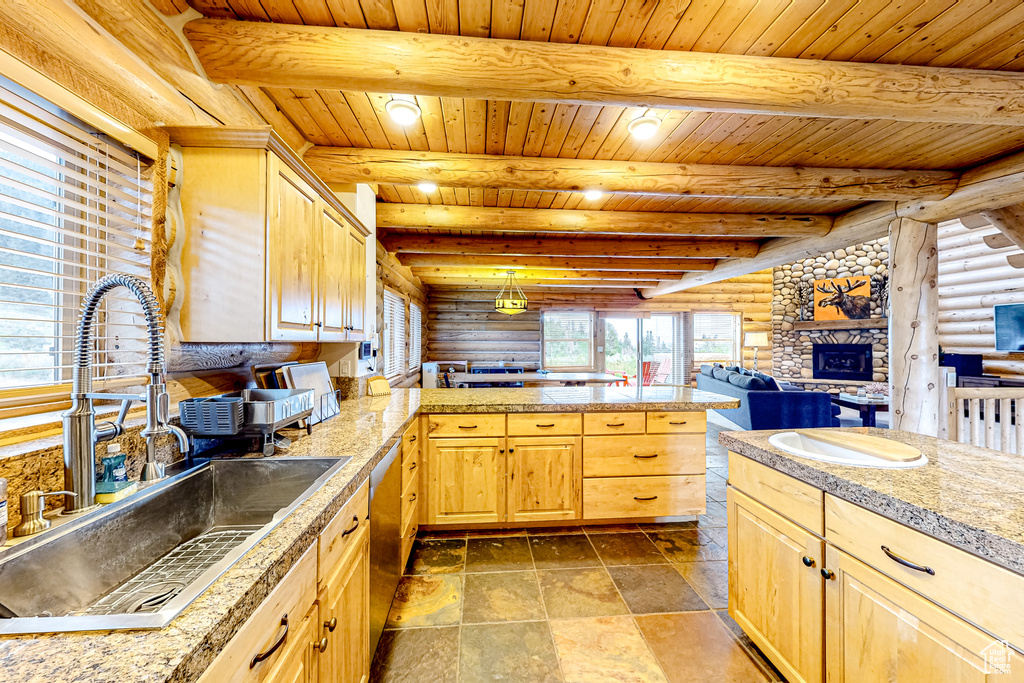Kitchen featuring a sink, tile countertops, log walls, light brown cabinetry, and dishwasher