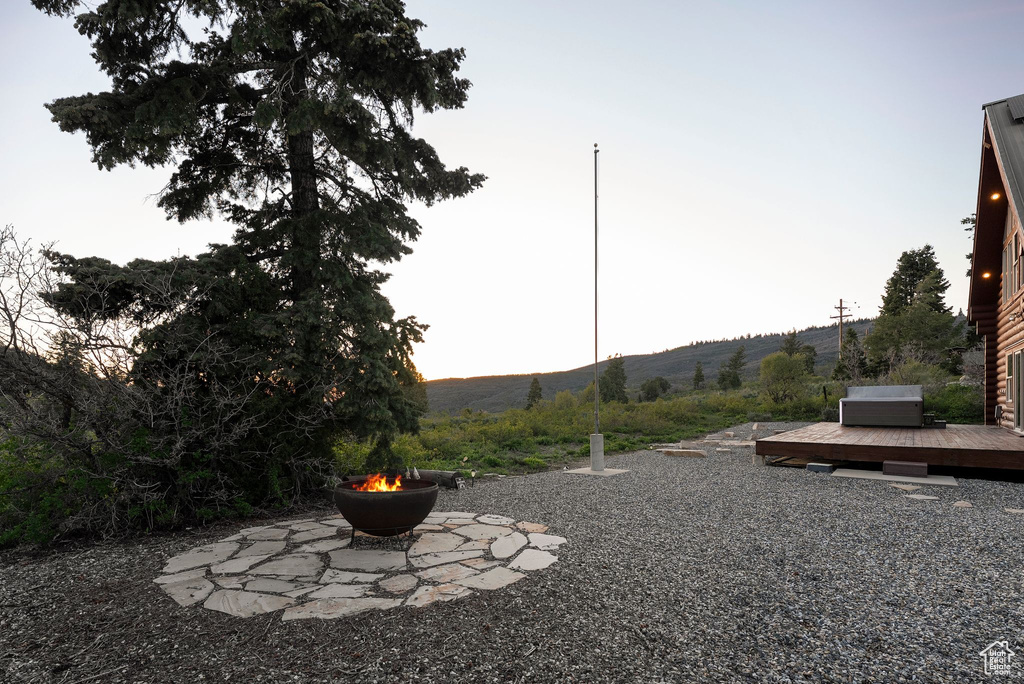 View of yard with an outdoor fire pit and a deck