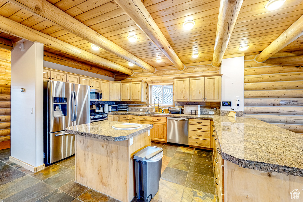 Kitchen with stainless steel appliances, light brown cabinets, log walls, wood ceiling with exposed beams, and a sink