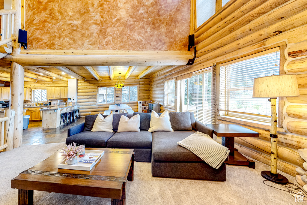 Living area featuring log walls and light colored carpet