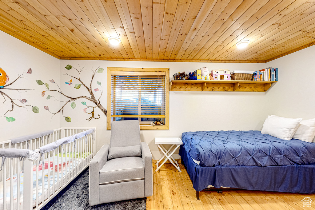 Bedroom with wooden ceiling, wood-type flooring, and ornamental molding