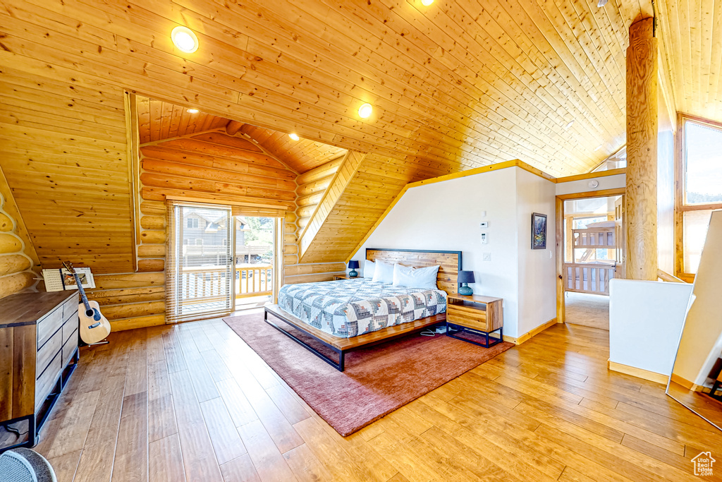 Bedroom with lofted ceiling, wood ceiling, log walls, access to exterior, and hardwood / wood-style floors