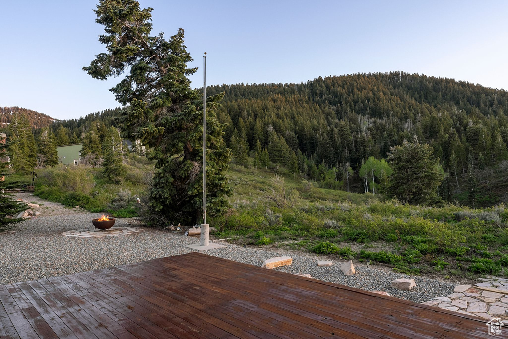 Deck featuring a wooded view and a mountain view