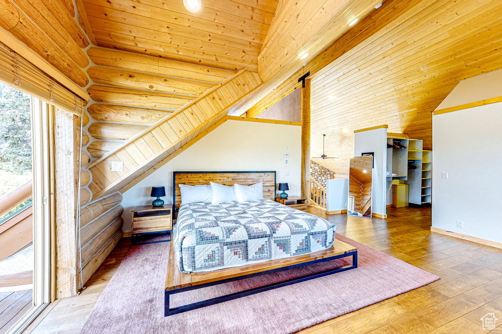 Bedroom featuring rustic walls, wood-type flooring, wood ceiling, and lofted ceiling