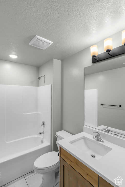 Full bath featuring a textured ceiling, bathing tub / shower combination, vanity, and toilet