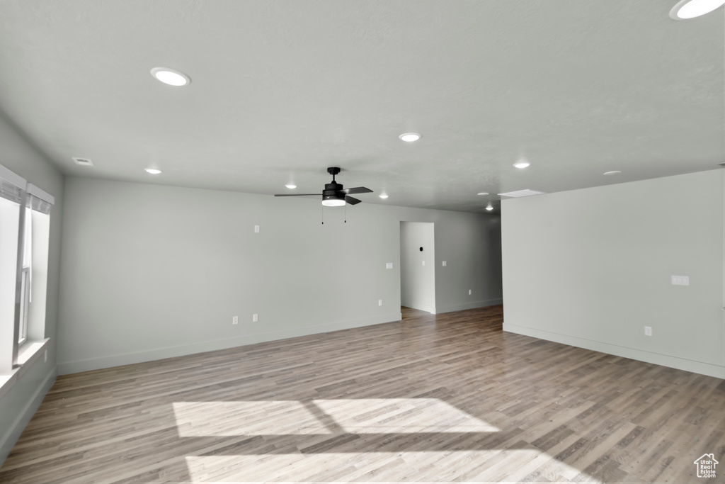 Empty room featuring recessed lighting, light wood-type flooring, ceiling fan, and baseboards