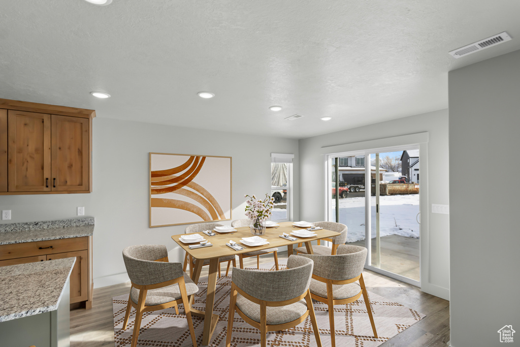 Dining space with light wood finished floors, recessed lighting, and baseboards