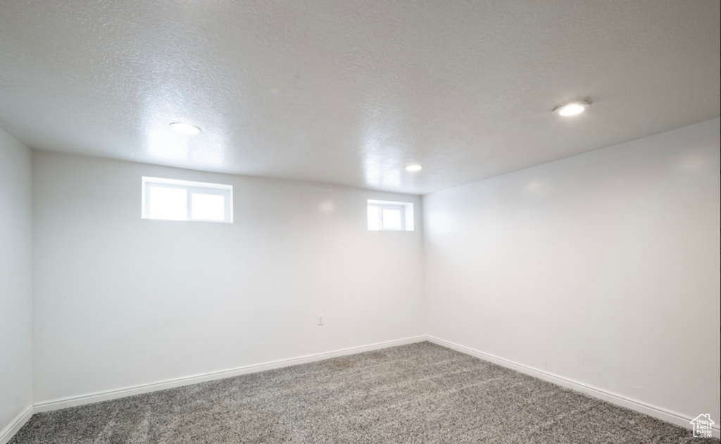 Basement with carpet flooring, plenty of natural light, baseboards, recessed lighting, and a textured ceiling