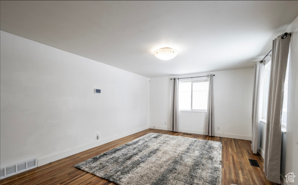 Spare room featuring baseboards and wood finished floors