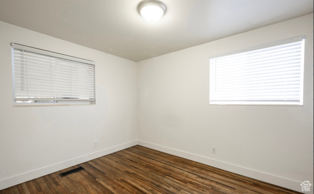 Spare room with baseboards and dark wood finished floors