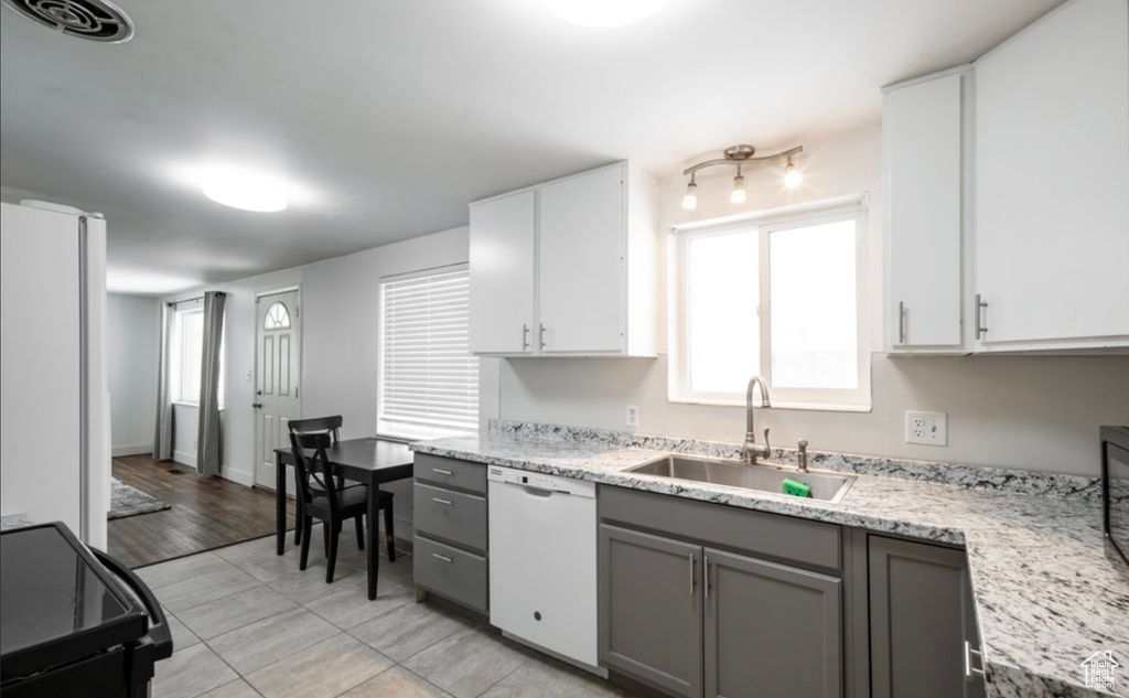 Kitchen featuring white appliances, a sink, gray cabinets, light tile patterned flooring, and white cabinetry