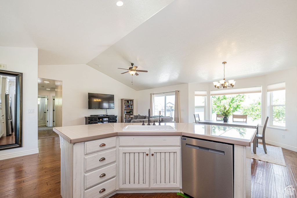 Kitchen featuring dishwasher, a sink, open floor plan, white cabinets, and a chandelier