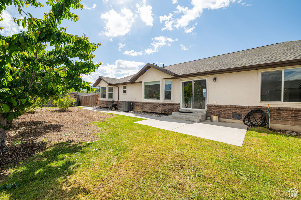 Rear view of house with brick siding, a patio, stucco siding, and roof with shingles