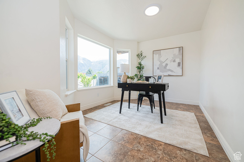 Office space with baseboards and a mountain view