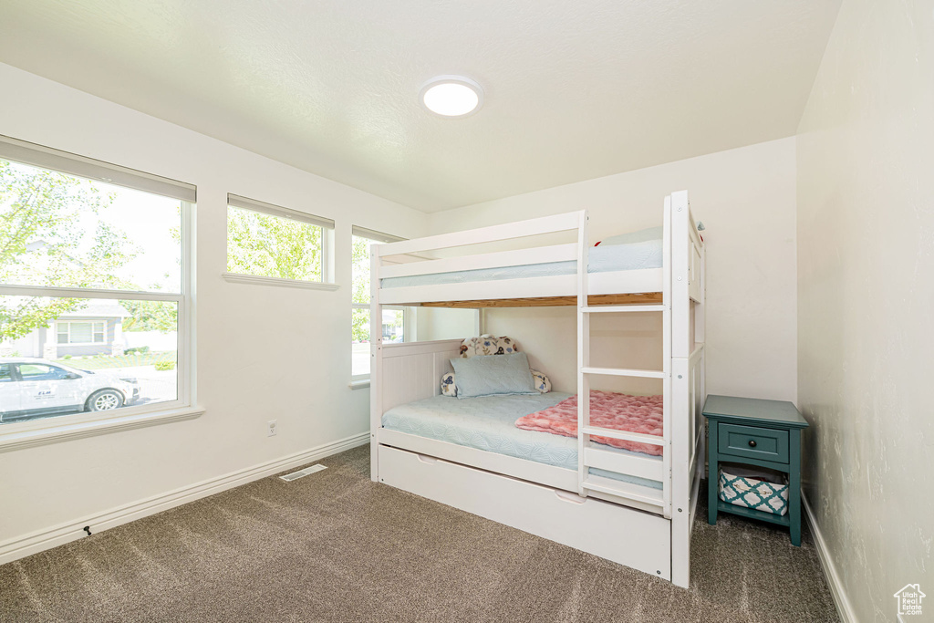 Bedroom featuring carpet floors, multiple windows, and baseboards