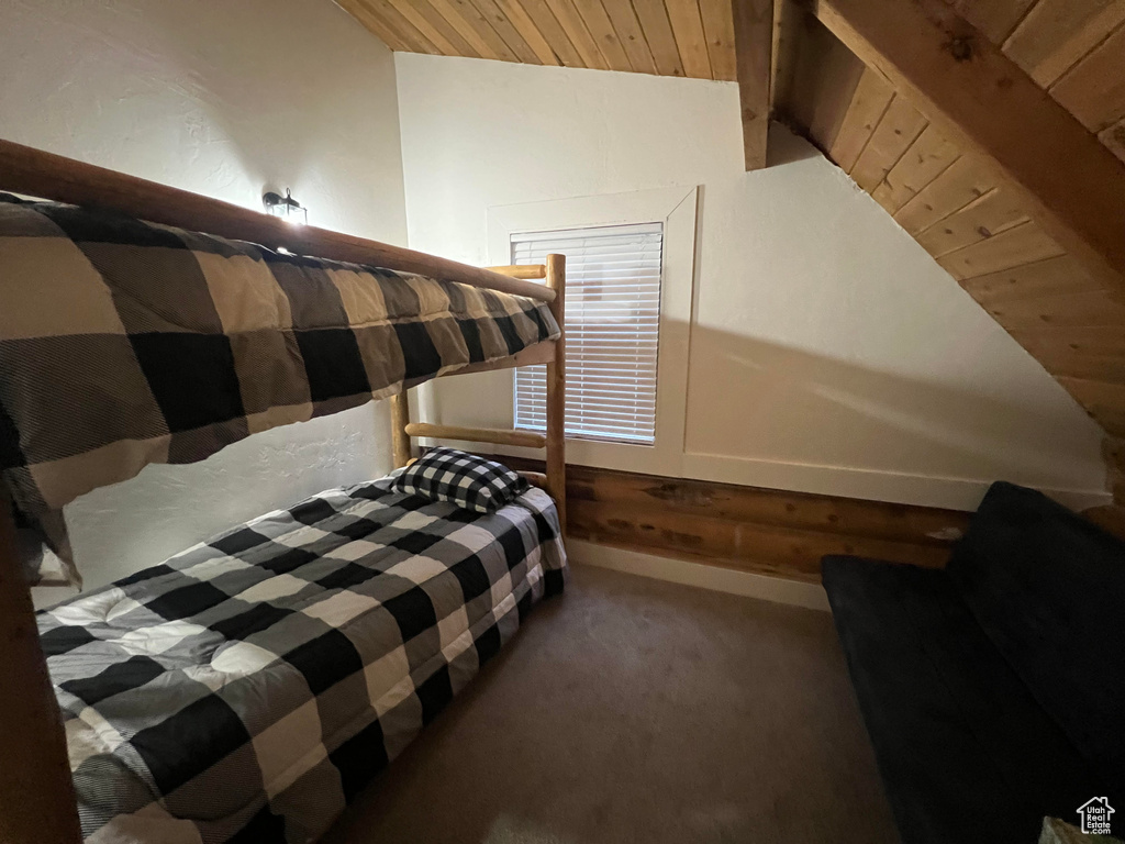 Carpeted bedroom featuring lofted ceiling, wood ceiling, and baseboards