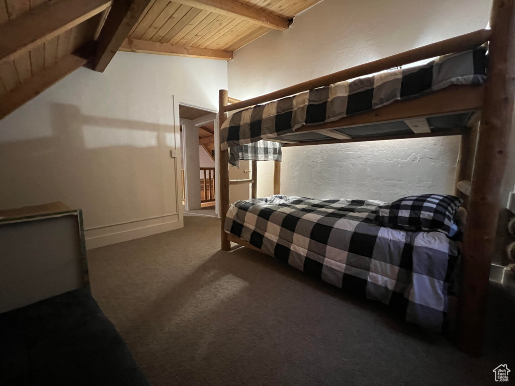 Carpeted bedroom with wood ceiling and baseboards