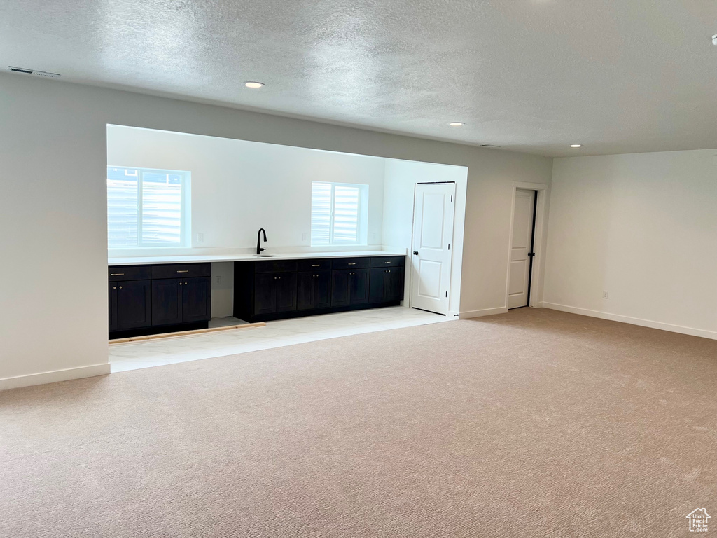 Spare room with light carpet, baseboards, plenty of natural light, recessed lighting, and a textured ceiling