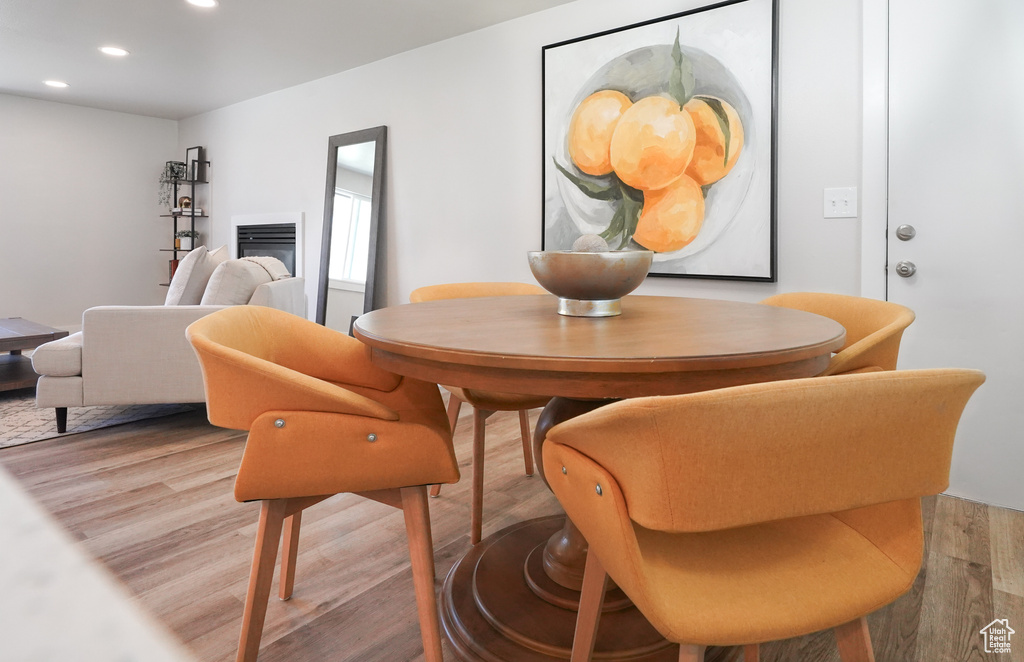 Dining area featuring recessed lighting, wood finished floors, and a glass covered fireplace
