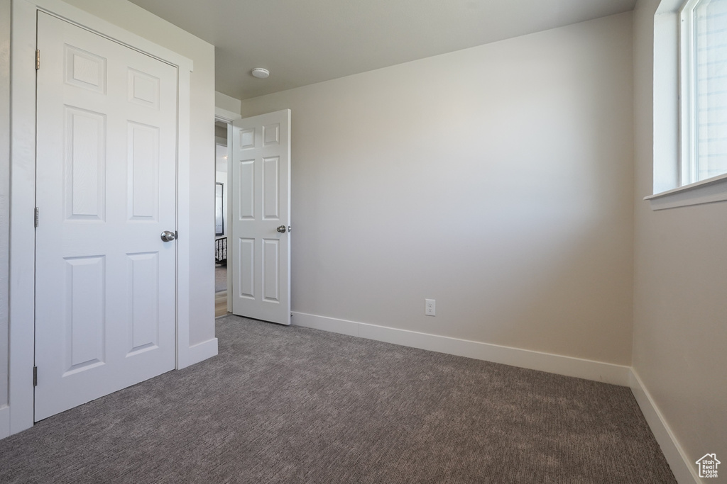 Unfurnished bedroom featuring carpet flooring and baseboards