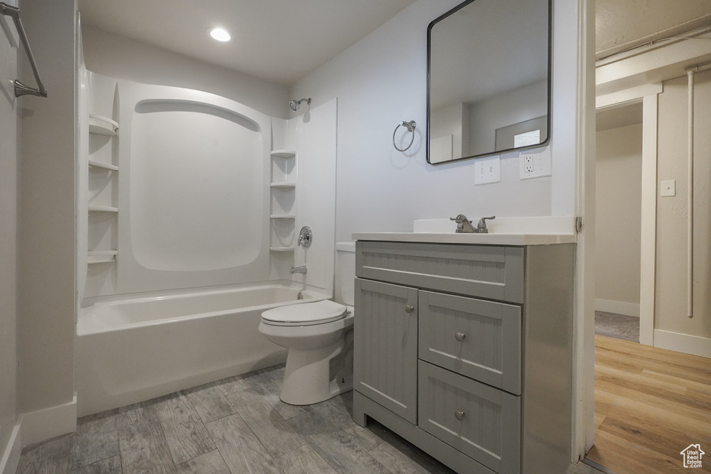 Bathroom with vanity, toilet, tub / shower combination, recessed lighting, and baseboards