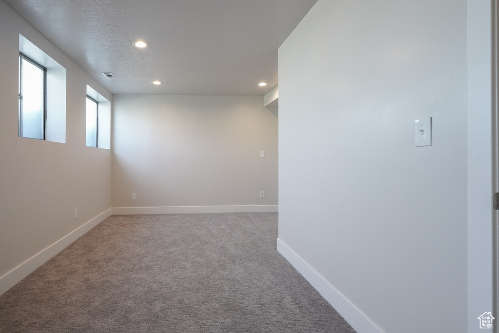 Carpeted spare room featuring recessed lighting and baseboards