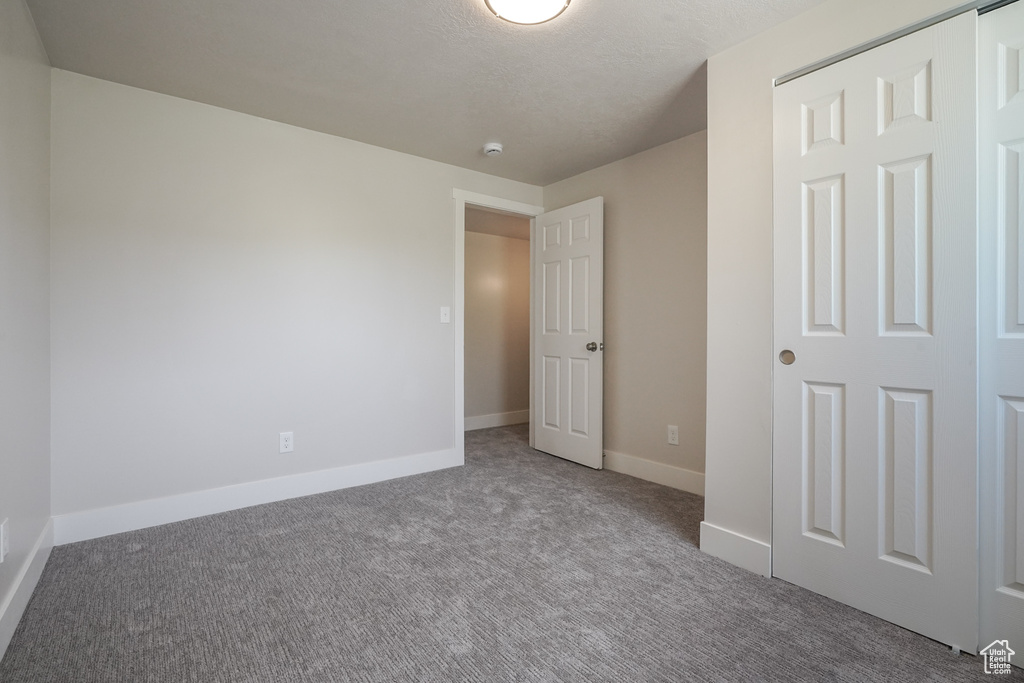 Unfurnished bedroom with carpet floors and baseboards