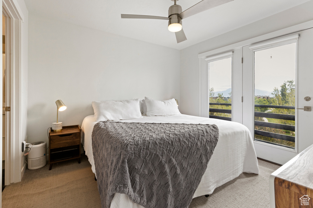 Bedroom with light colored carpet, access to exterior, and ceiling fan