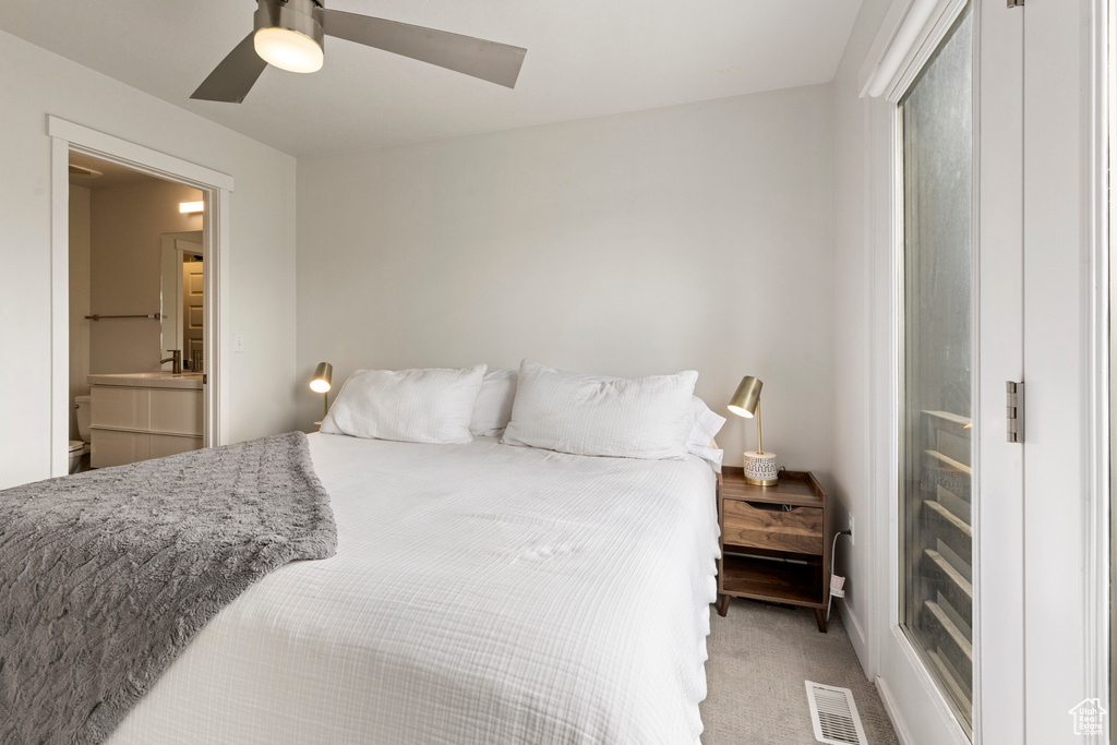 Bedroom with light colored carpet and a ceiling fan