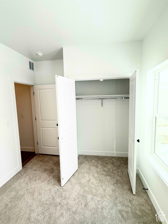 Unfurnished bedroom featuring carpet, a closet, and baseboards