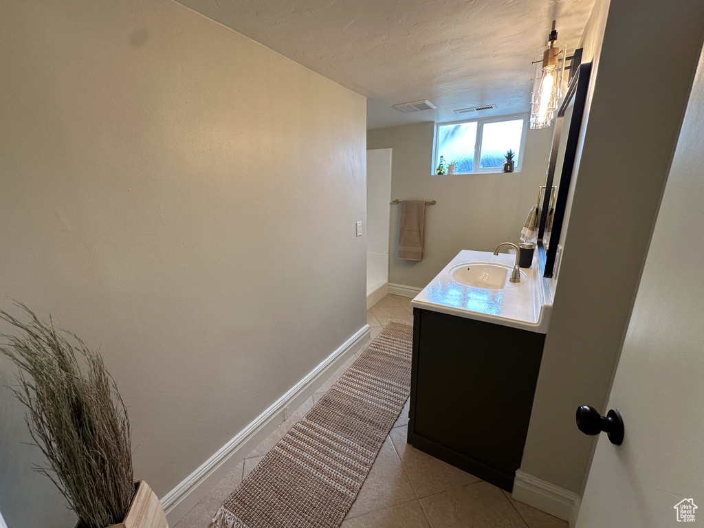 Bathroom featuring vanity, tile patterned flooring, and baseboards