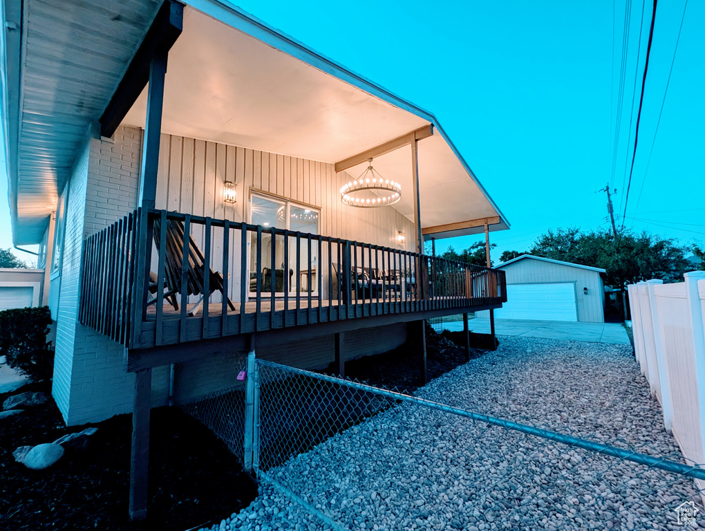 Back of house featuring brick siding, an outdoor structure, and a deck