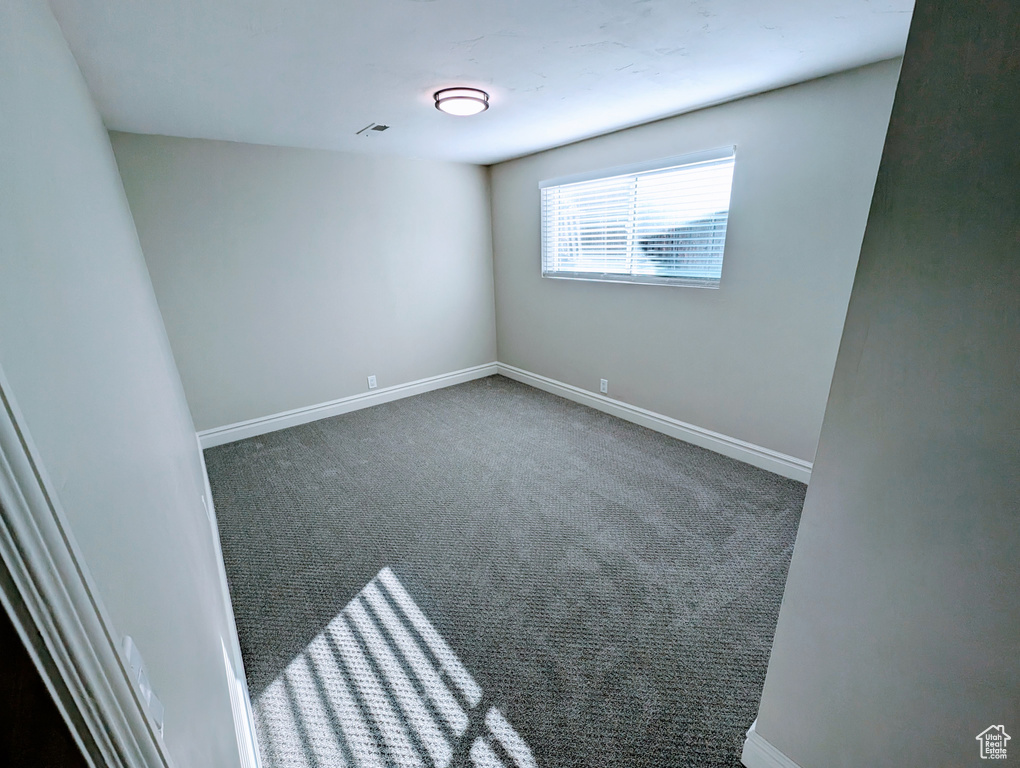 Spare room featuring baseboards and carpet flooring
