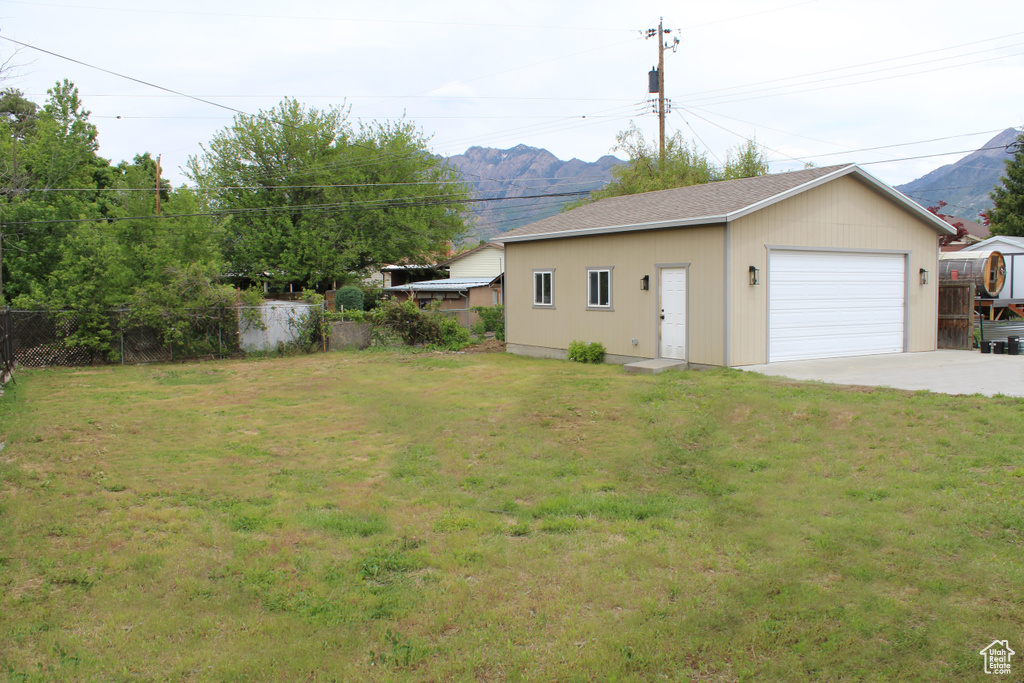 View of yard featuring a garage, a mountain view, and an outdoor structure