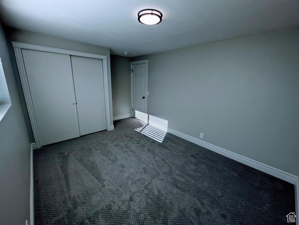 Unfurnished bedroom with a closet, baseboards, and carpet floors