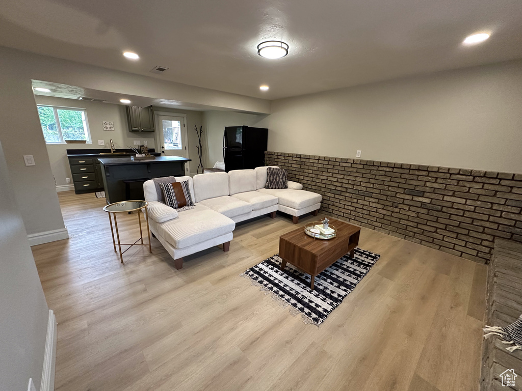 Living room with light wood finished floors, recessed lighting, and baseboards