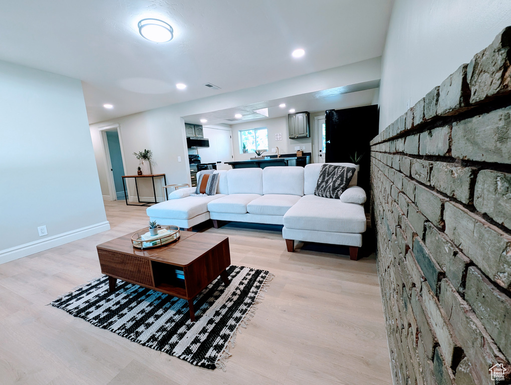 Living room with light wood-style flooring, recessed lighting, and baseboards