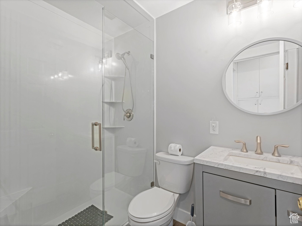Full bath featuring a shower stall, toilet, and vanity