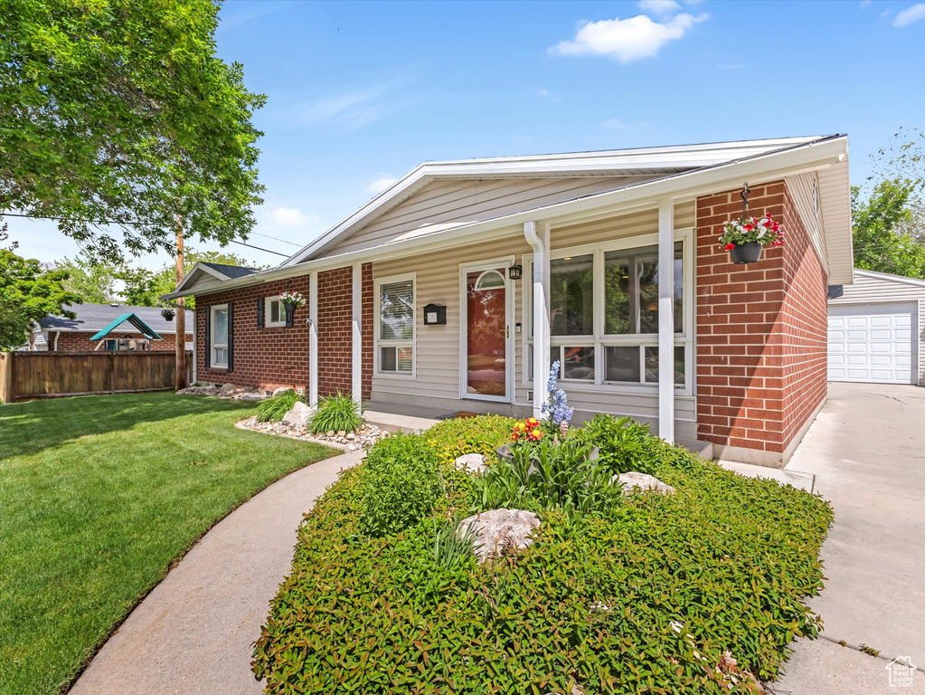 Ranch-style home with brick siding, an outdoor structure, covered porch, and a detached garage